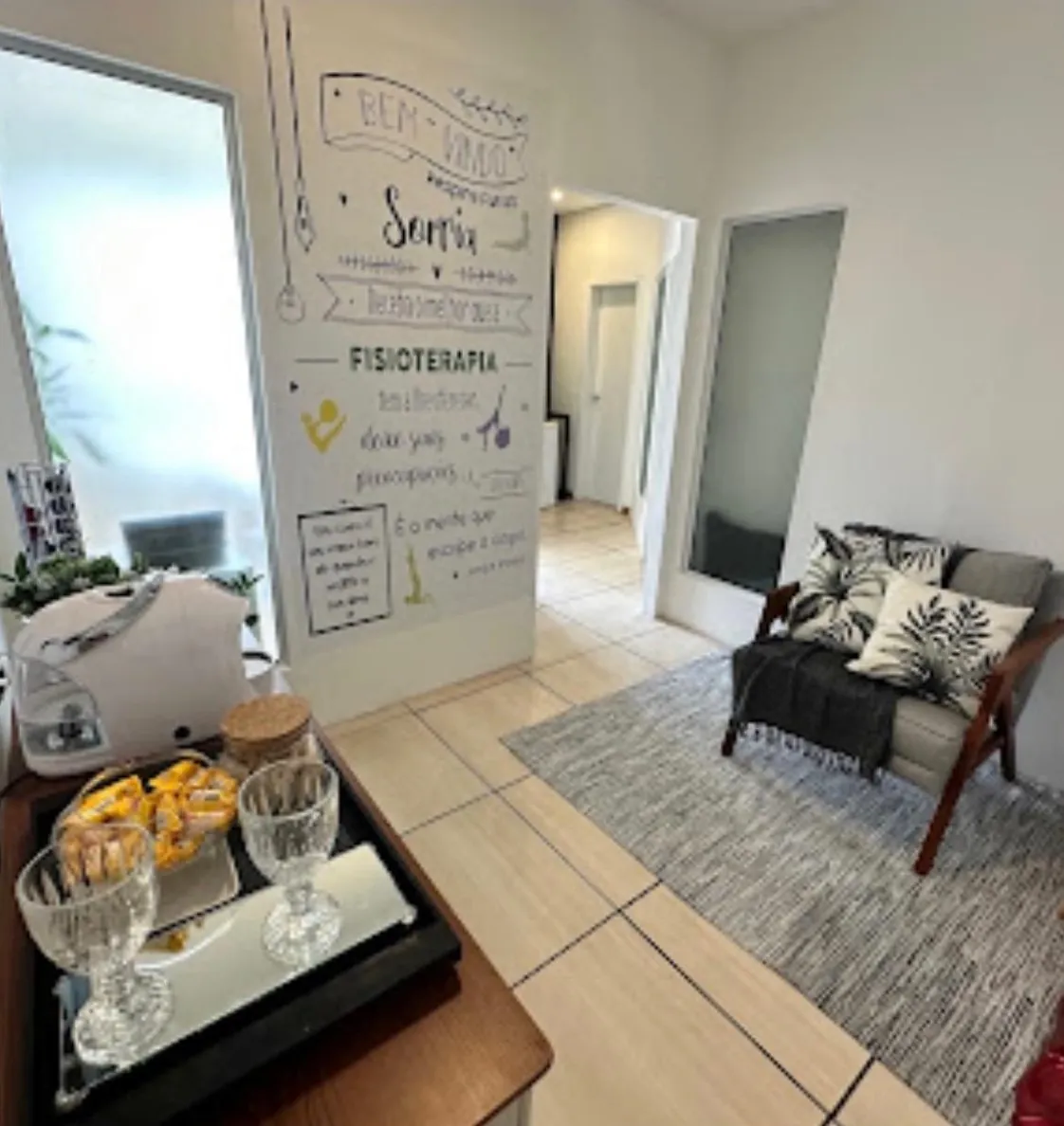 Recepção da clínica de fisioterapia com sofá e parede decorada
